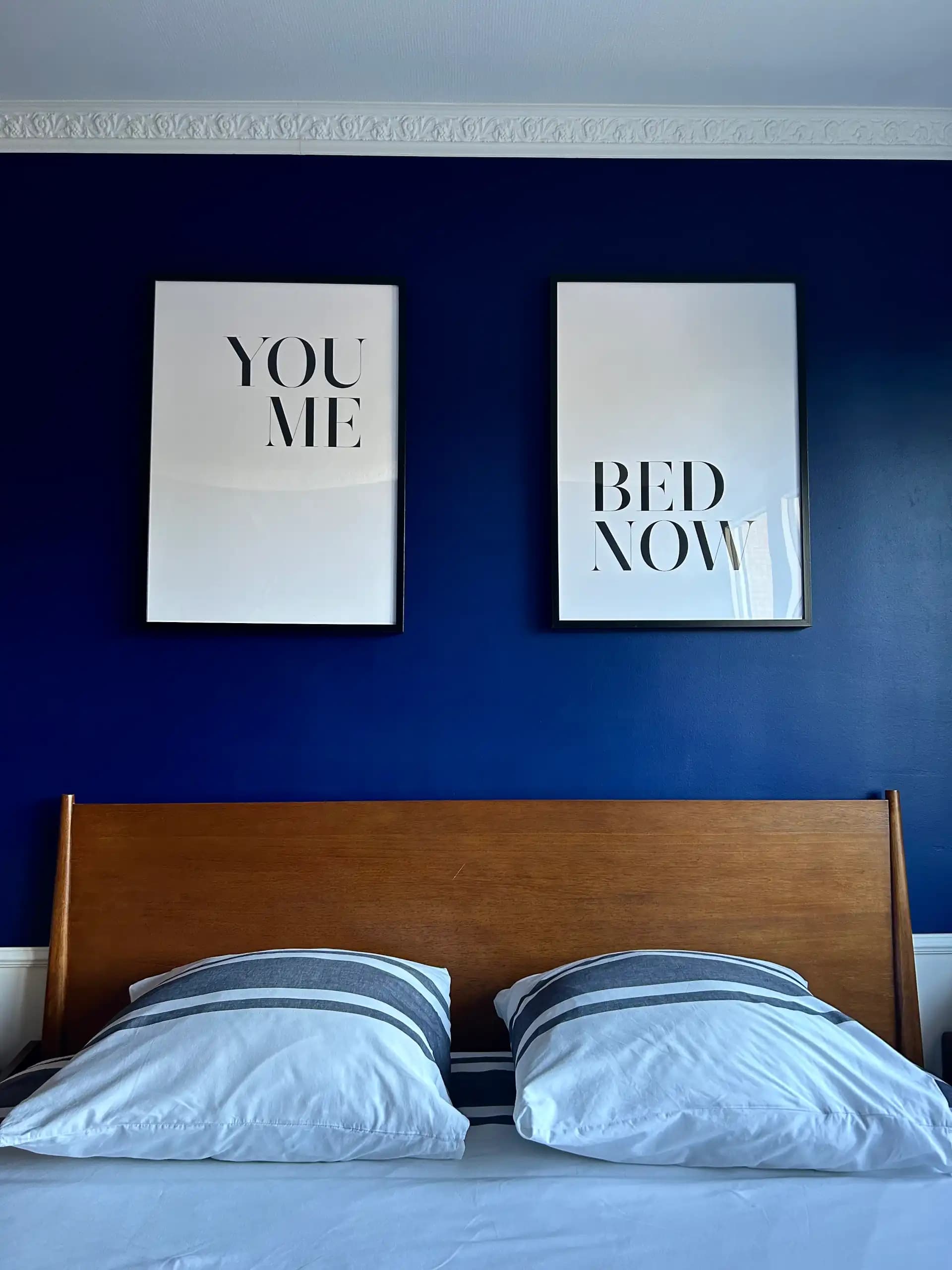 Le lit et les cadres dans la chambre de l'appartement le berthollet à annecy